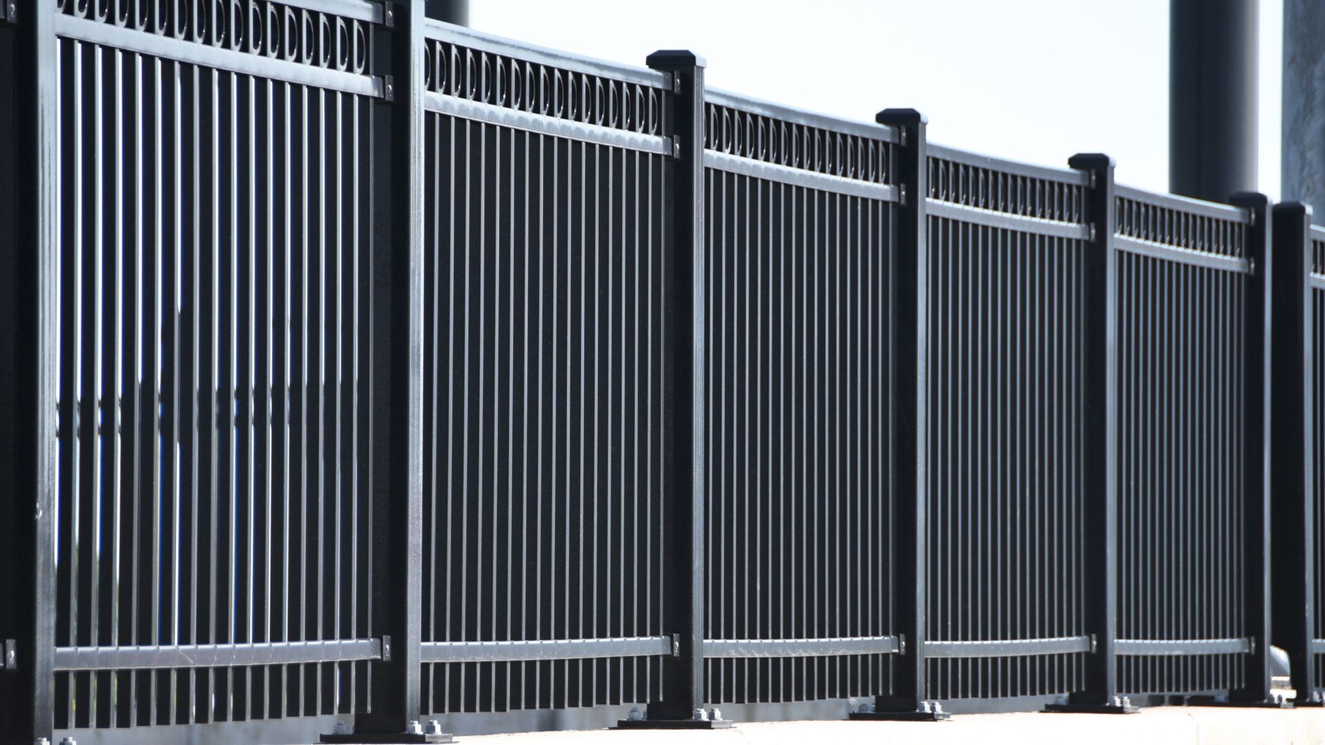 Black metal fence with vertical bars and horizontal supports